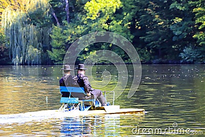 2 Hasidic Jews ride a catamaran on the lake in the autumn Park in Uman, Ukraine, during the Jewish New Year Editorial Stock Photo