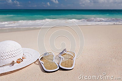 Hat and flip-flops on the beach Stock Photo