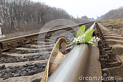 Hat and flowers lies on the train rails. Stock Photo