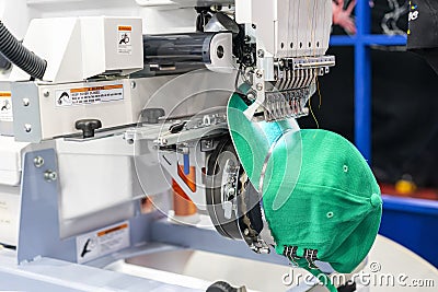 Hat sewing at modern and automatic high technology embroidery machine for textile - clothing apparel making manufacturing process Stock Photo