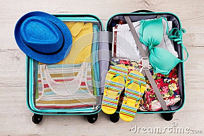 Hat and slippers on packed suitcase. Stock Photo