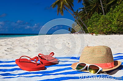 Hat, sun glasses and flip flops on a tropical beach Stock Photo