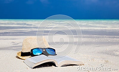 Hat, sunglasses and a book on the beach Stock Photo