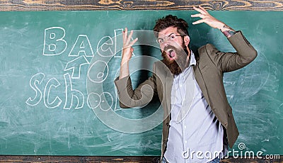 Hate school. Teacher goes mad about schooling. Teacher or educator stands near chalkboard with inscription back to Stock Photo