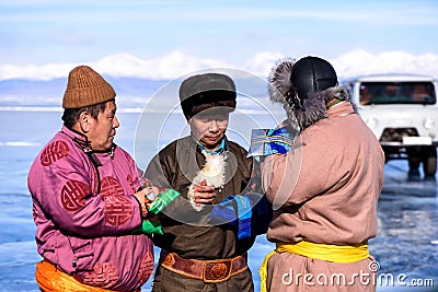 Hatgal, Mongolia, Febrary 23, 2018: mongolian people dressed in traditional clothing on a frozen lake Khuvsgul and Editorial Stock Photo