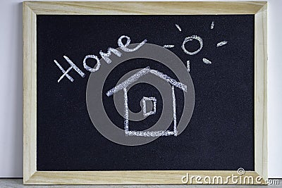 Hause and sun painted with chalk and the inscription home. Wooden chalkboard with picture. Happy, sweet home and family concept. Stock Photo