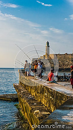 Havana, Cuba. June 2018. El Malecon of Havana: cuban people fishing at sunset. Editorial Stock Photo