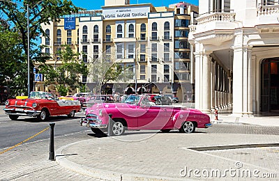 American pink convertible 1951 Chevrolet Styleline Deluxe and a red 1955 Pontiac Star Chief on the street in the old town from Hav Editorial Stock Photo