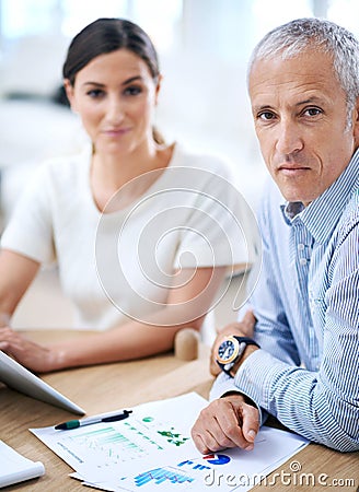 The have fulfilling careers. Portrait of two businesspeople sitting together at a desk. Stock Photo