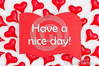 Have a nice day message on red wood sign with red hearts on white fabric Stock Photo