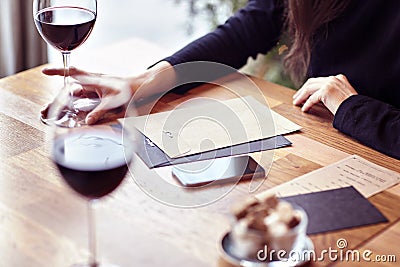 Having lunch with glasses red wine in a cafe. Friends meeting indoor. Hipster paper envelope Stock Photo