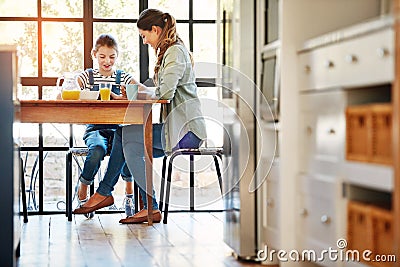 Having the most important meal of the day with mom. a happy mother and daughter enjoying breakfast together at home. Stock Photo