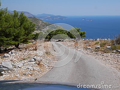 Having a ride near Dubrovik, Croatia - mountain road, car bonnet and coast line view Stock Photo