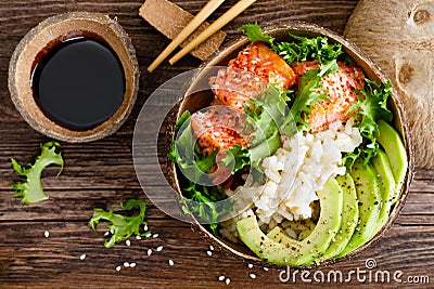Hawaiian poke coconut bowl with grilled salmon fish, rice and avocado. Healthy food Stock Photo