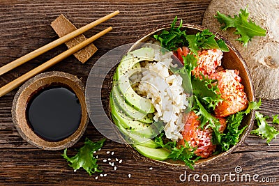 Hawaiian poke coconut bowl with grilled salmon fish, rice and avocado. Healthy food Stock Photo