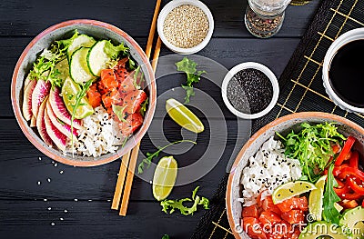 Hawaiian salmon fish poke bowl with rice, avocado, paprika, cucumber, radish, sesame seeds and lime. Buddha bowl. Diet food. Top Stock Photo