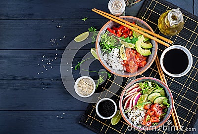 Hawaiian salmon fish poke bowl with rice, avocado, paprika, cucumber, radish, sesame seeds and lime. Buddha bowl. Diet food. Top Stock Photo