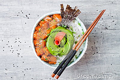 Hawaiian salmon poke bowl with seaweed, avocado rose, sesame seeds and scallions. Stock Photo