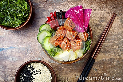 Hawaiian salmon poke bowl with seaweed, watermelon radish, cucumber, pineapple and sesame seeds. Copy space Stock Photo