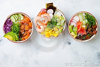 Hawaiian salmon, tuna and shrimp poke bowls with seaweed, avocado, mango, pickled ginger, sesame seeds. Stock Photo