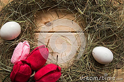 Hay frame, tulips and eggs on wooden background, top view. Stock Photo