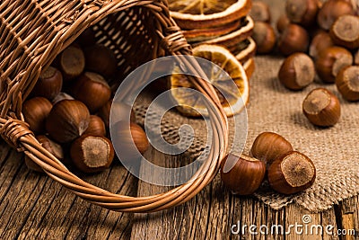 Hazelnuts in a basket on old wooden table. Stock Photo