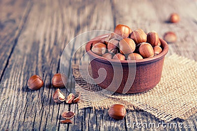 Hazelnuts in a bowl on a wooden table. Delicacies. healthy and beneficial food, vintage wooden background, selective focus Stock Photo