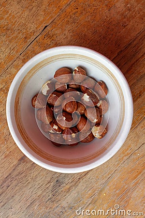 Hazelnuts in a partly emptied bowl Stock Photo