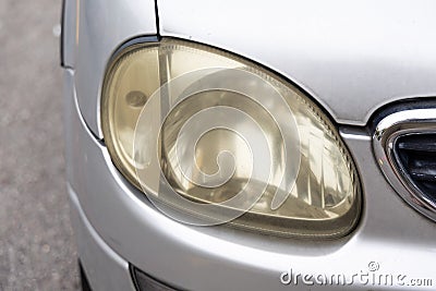 Hazy opaque yellowed front head lamp of car reduces light pass-through and driving visibility Stock Photo