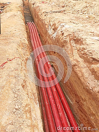 HDPE conduit pipe power conduit installed inside the ground trench. Editorial Stock Photo