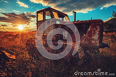 HDR image of old rusty tractor in a field. Sunset shot Stock Photo