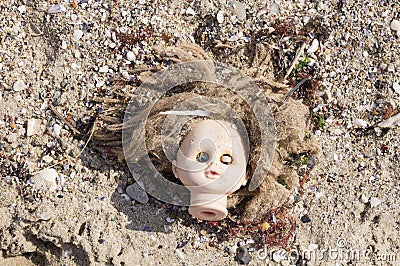 Head of children's doll on the beach trash Stock Photo