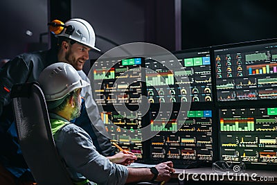 Head engineer and factory operator following product process on factory uses SCADA system and industry 4.0. Two operators controll Stock Photo