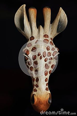 Wooden giraffe head close up black background