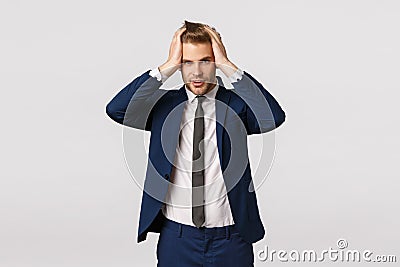 Head going crazy, being busy. Handsome young troubled businessman starting own company, having problems, touching hair Stock Photo