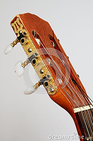 Head guitar neck with tuning pegs on gray Stock Photo