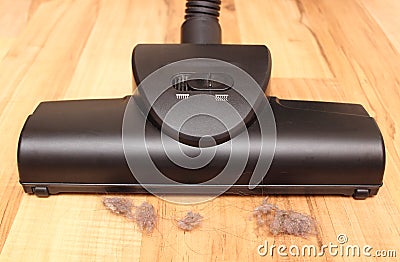Head of modern vacuum cleaner on wooden floor with dust Stock Photo