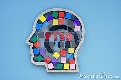 Head outline with colored cubes and inscription PTSD Post Traumatic Stress Disorder. Stock Photo
