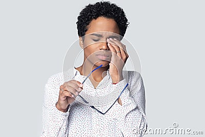 Exhausted millennial ethnic woman rubbing irritated eyes. Stock Photo