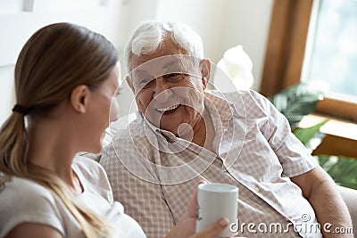 Happy old man talking with smiling grown up adult daughter. Stock Photo