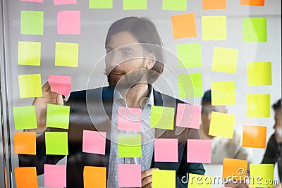 Head shot focused young professional standing near kanban board. Stock Photo