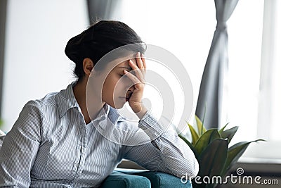 Unhappy stressed millennial indian ethnicity woman hiding face in hands. Stock Photo