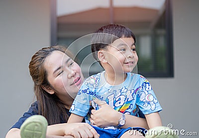 Head shot happy young Asian woman cuddling talking to small kid son Stock Photo
