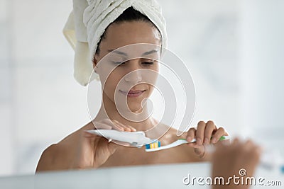 Head shot mirror reflection beautiful woman applying toothpaste on toothbrush Stock Photo