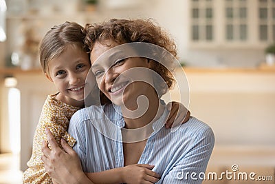 Sincere little kid daughter cuddling young mother. Stock Photo