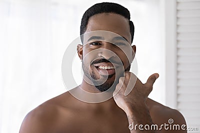 Head shot portrait smiling African American man touching beard Stock Photo