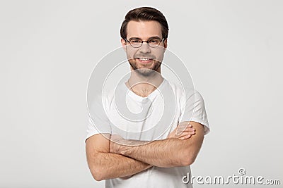 Happy millennial confident man in glasses standing with folded hands. Stock Photo