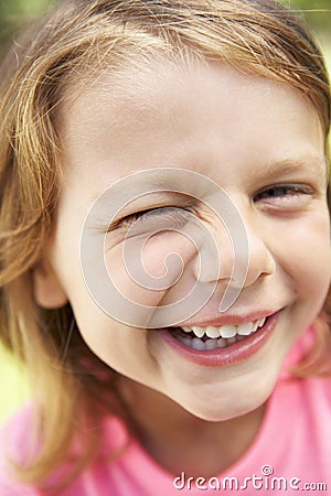 Head And Shoulders Portrait Of Winking Girl Stock Photo