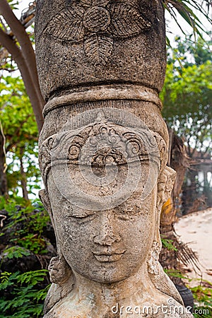 The head of a statue of a woman in an ancient national headdress in a tropical park. Travel and tourism in Asia Stock Photo