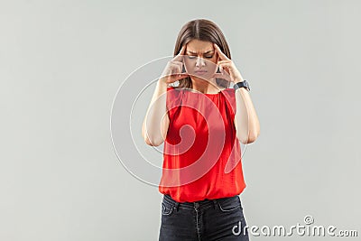 Headache, confution or thinking. Portrait of serious beautiful brunette young woman in red shirt standing and holding her painful Stock Photo